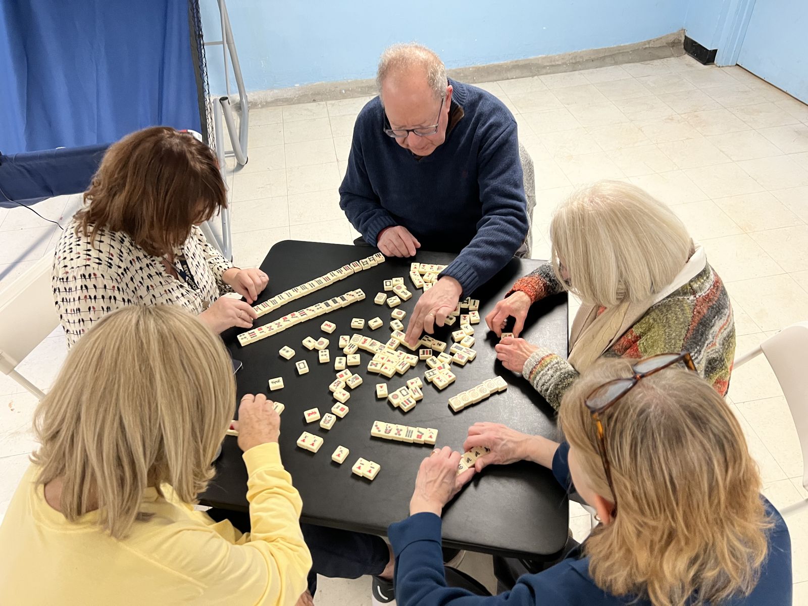 Dave teaching a full room of mahjong students at a community hall